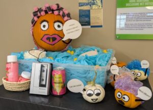 orange pumpkin with hair in curlers dressed like a mom in a fake bathtub with a speech bubble that says "...ahhhh! after a long day i can finally rest!" surrounded by bath products, rubber ducks, walkman, and canned mimosa. small pumpkins surround the tub saying "mama," "mommy," "mom, mom!!" "can we come!" like small children.